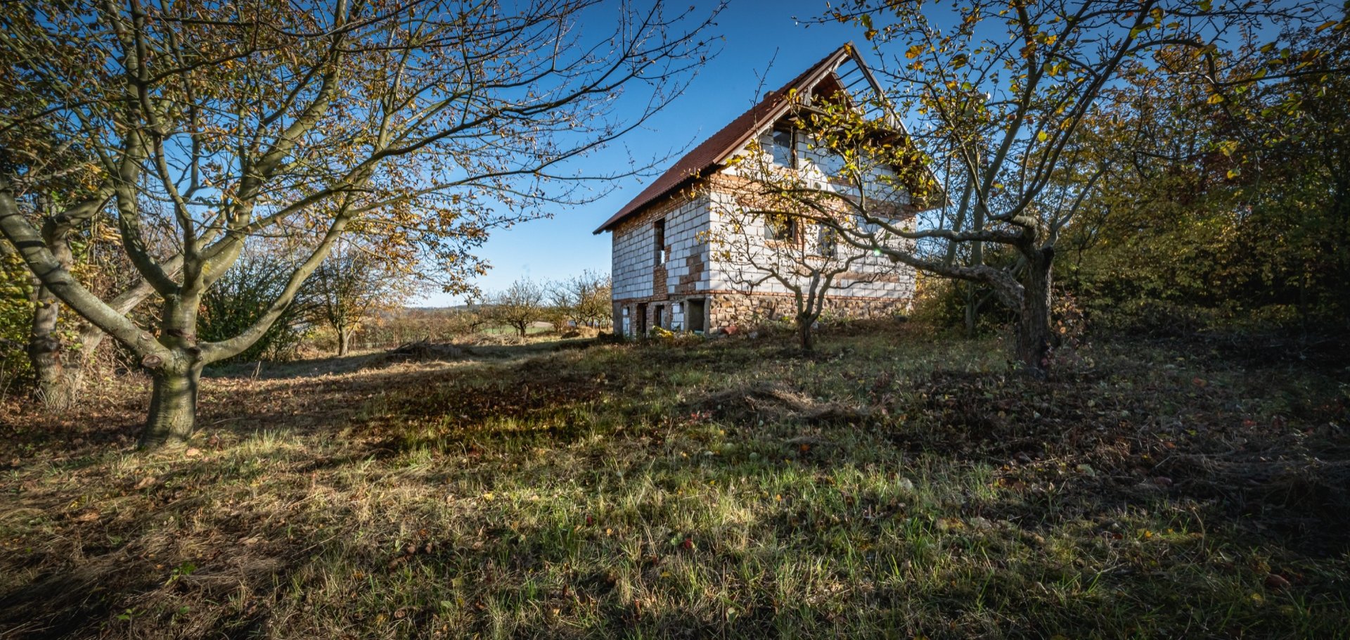 Pozemek s rozestavěným domem v Podřipsku